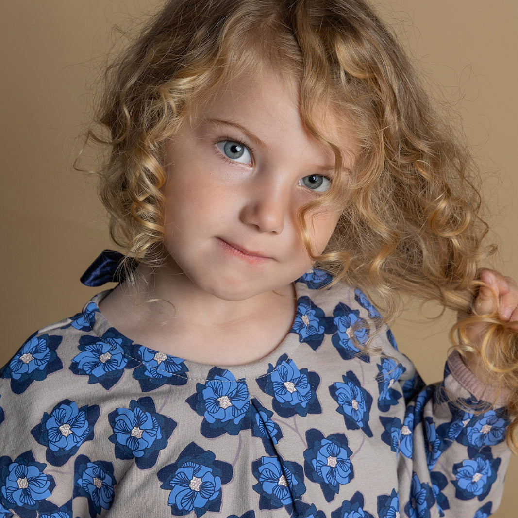 Pige i økologisk kjole med blåt blomsterprint